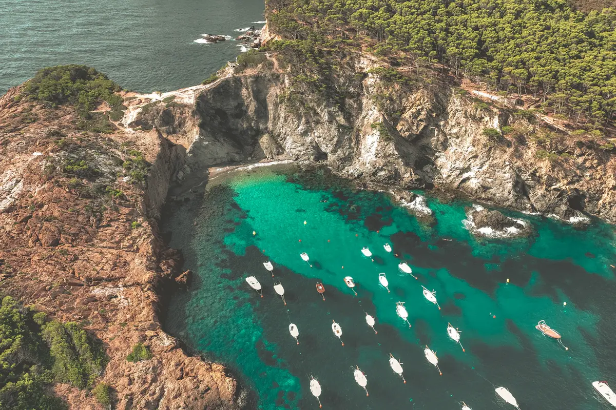 Vista aérea de una cala de la Costa Brava con pequeñas embarcaciones