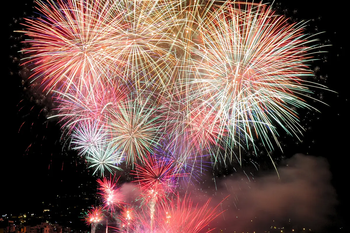 Fuegos artificiales sobre la costa durante una fiesta de verano