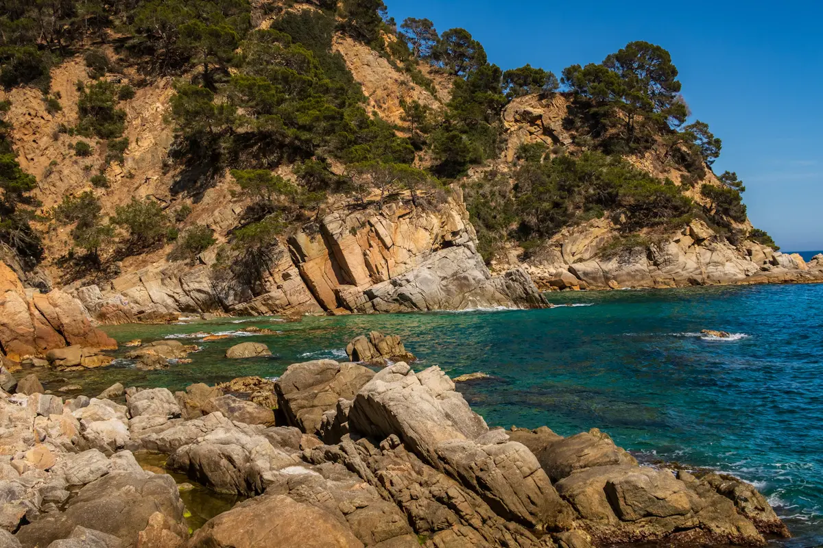 Cala rocosa de aguas transparentes en Lloret de Mar